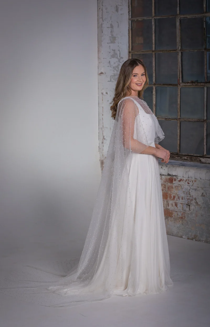 Pearl Cape main side over Mackenzie Wedding Dress Orchid Collection Natalya James 2025-308.png